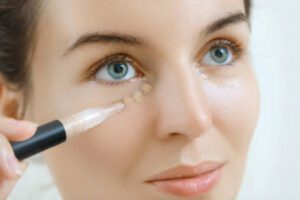 Woman using concealer for under eye circles