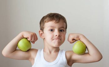 nutrition boy with green apples showing biceps face